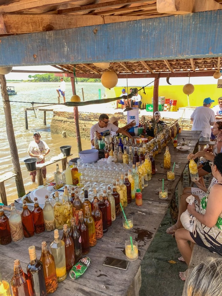 Turistas desembarcando da lancha na areia ao pé das dunas no passeio combo