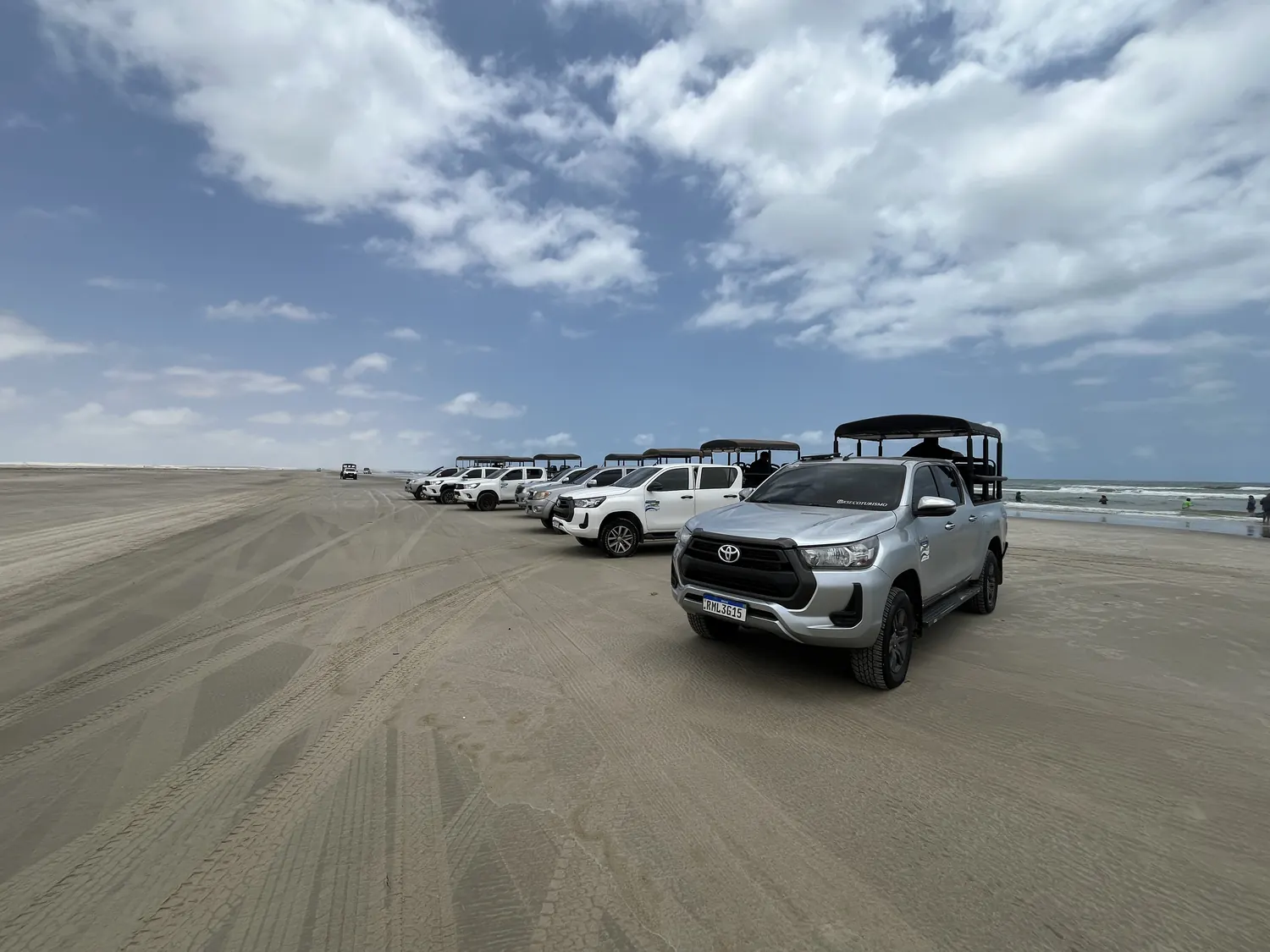 Fila de 4x4 na faixa de areia do Canto de Atins, com o mar ao lado