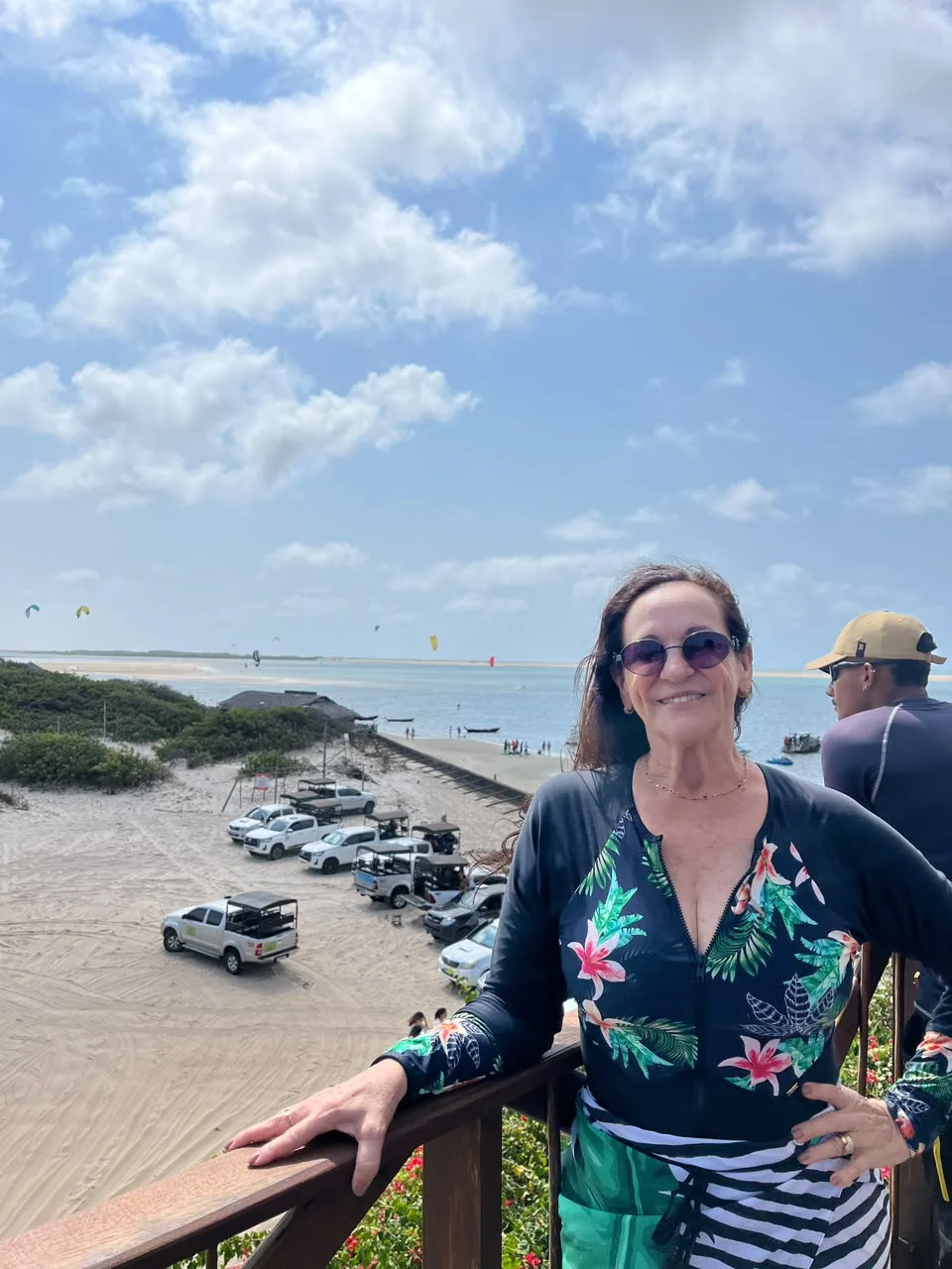 Visitante no mirante de Atins, com os 4x4 estacionados na areia e o mar com kitesurf ao fundo