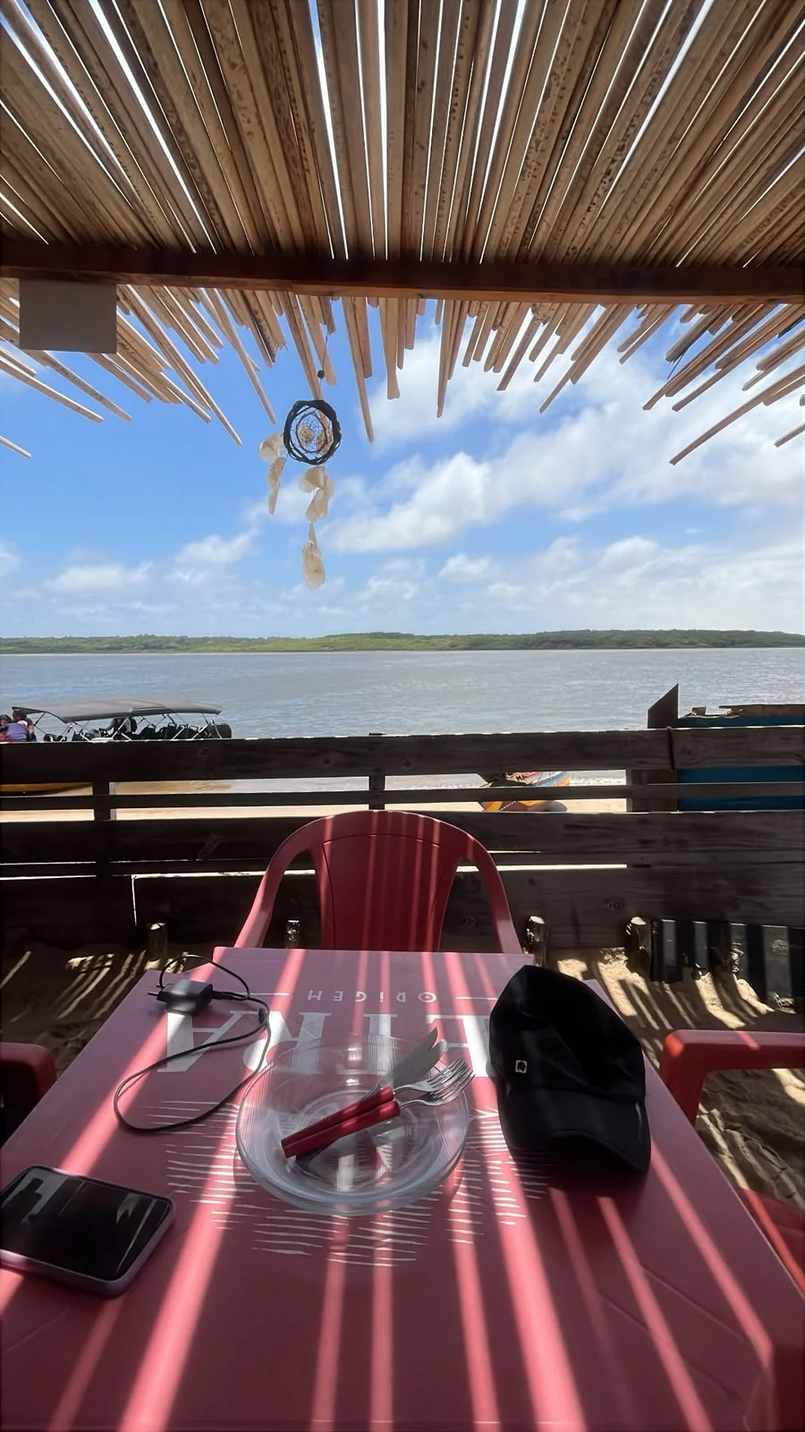 Mesa de restaurante a orillas del río Preguiças en Caburé, con vista al río y a las lanchas