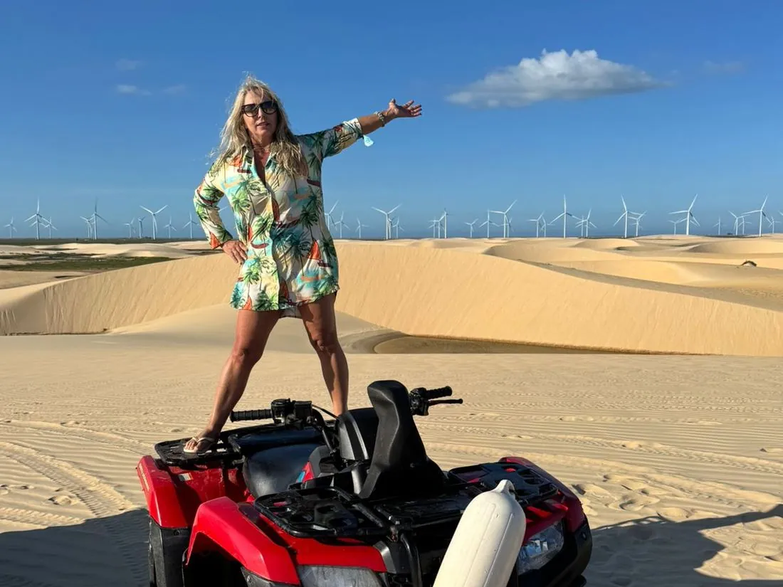Visitor standing on the ATV celebrating among the dunes of the Lençóis