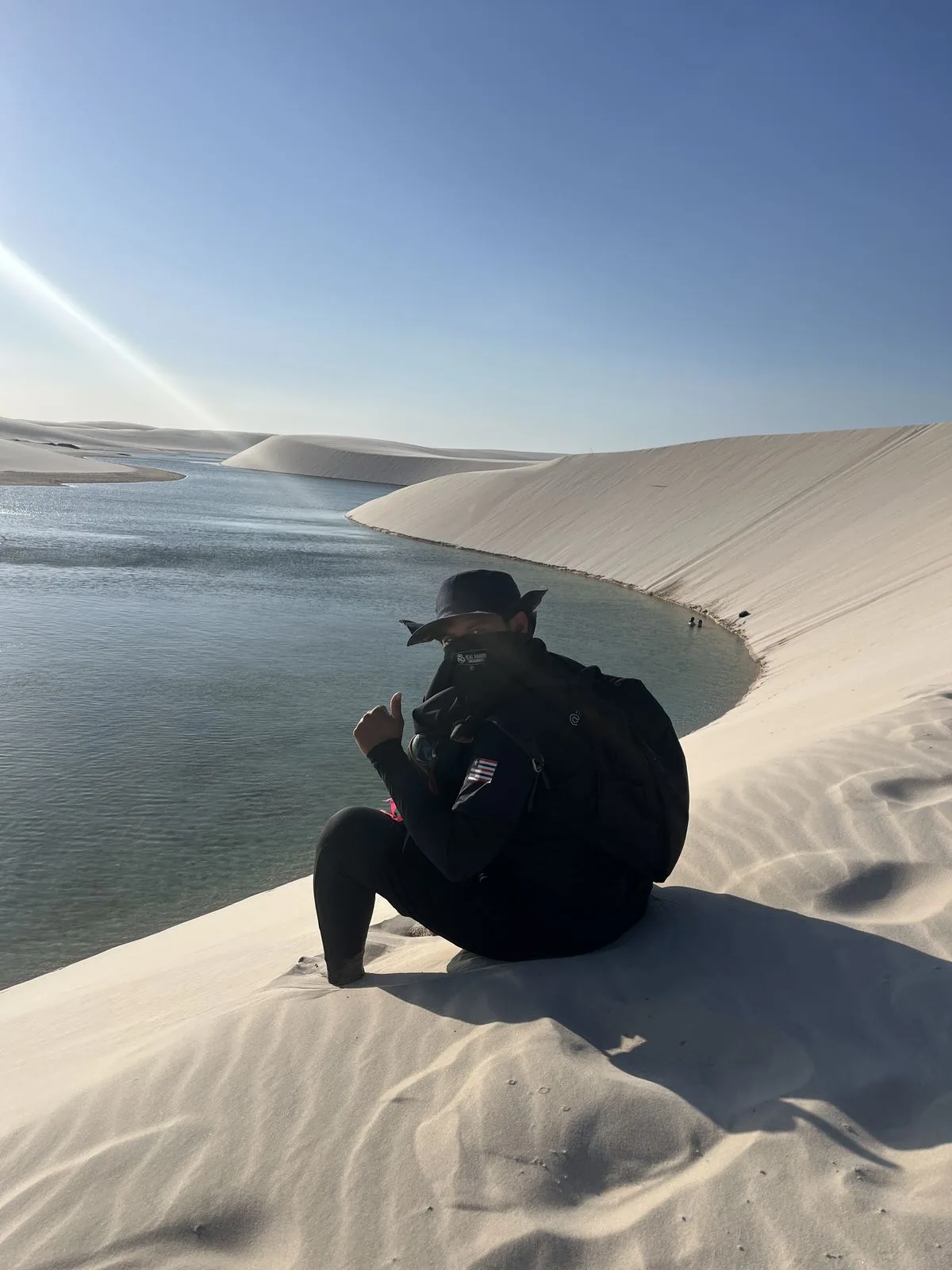 Guia saudando a câmera na duna à beira da lagoa