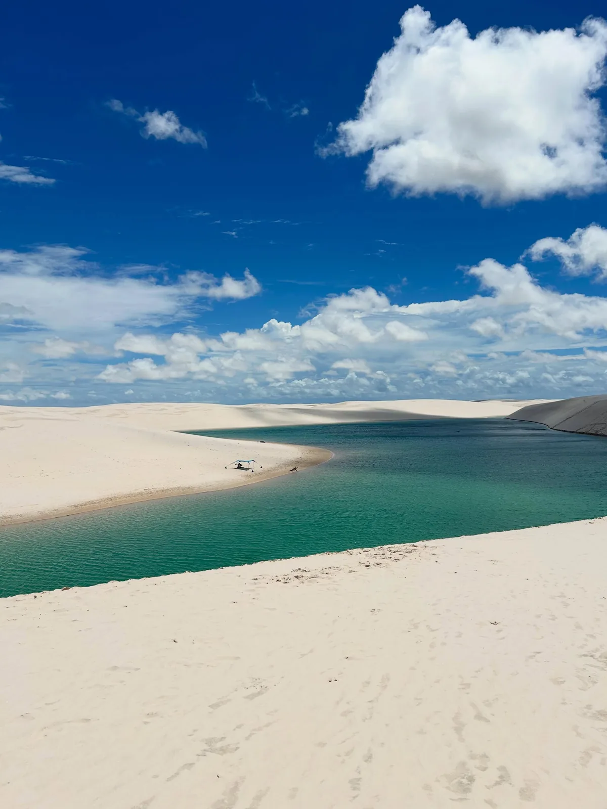 Lagoa Azul de águas esverdeadas entre as dunas, com a tenda de apoio na margem
