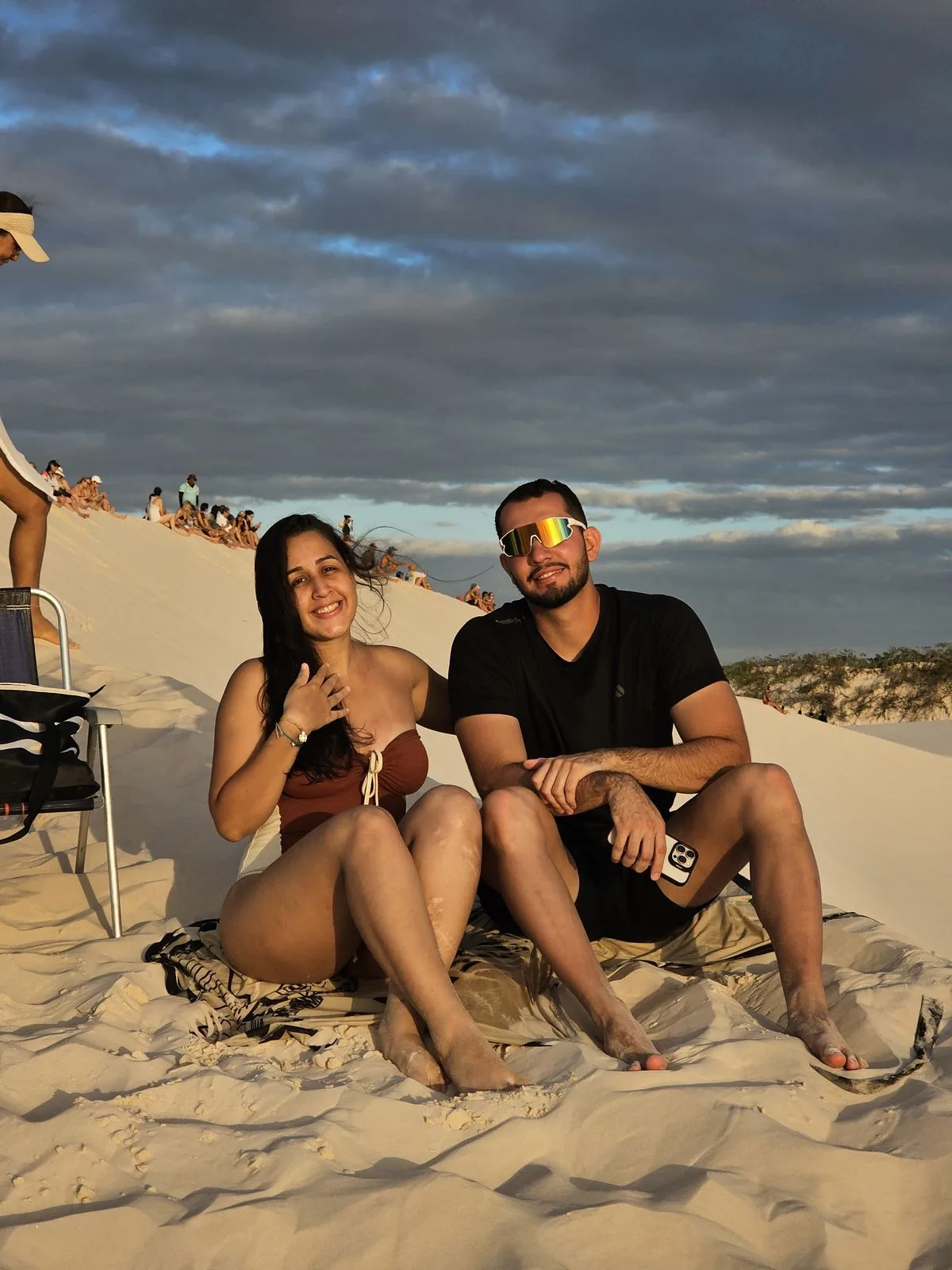 Couple sitting on the dune at dusk, at Lagoa Bonita