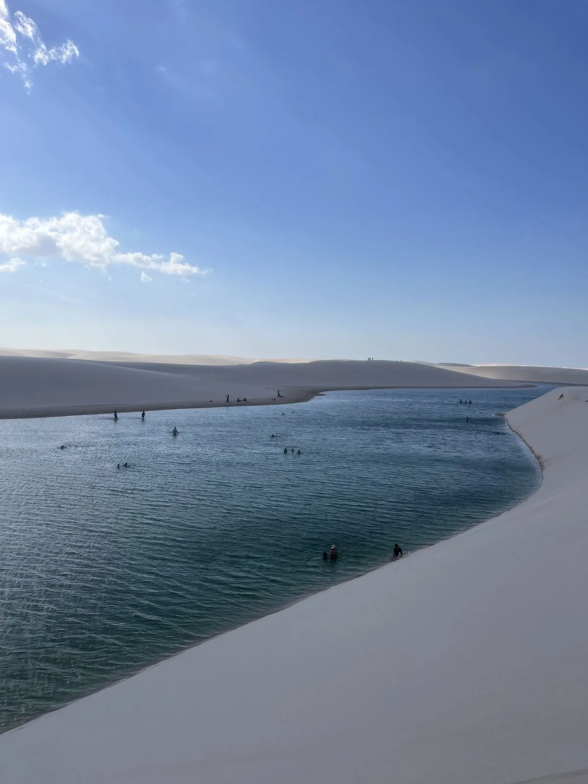 View of Lagoa Bonita from the top of the dune, with swimmers in the water