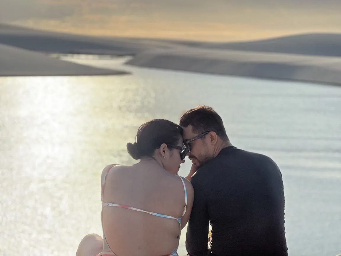 Casal sentado na duna admirando o fim de tarde sobre as lagoas dos Lençóis
