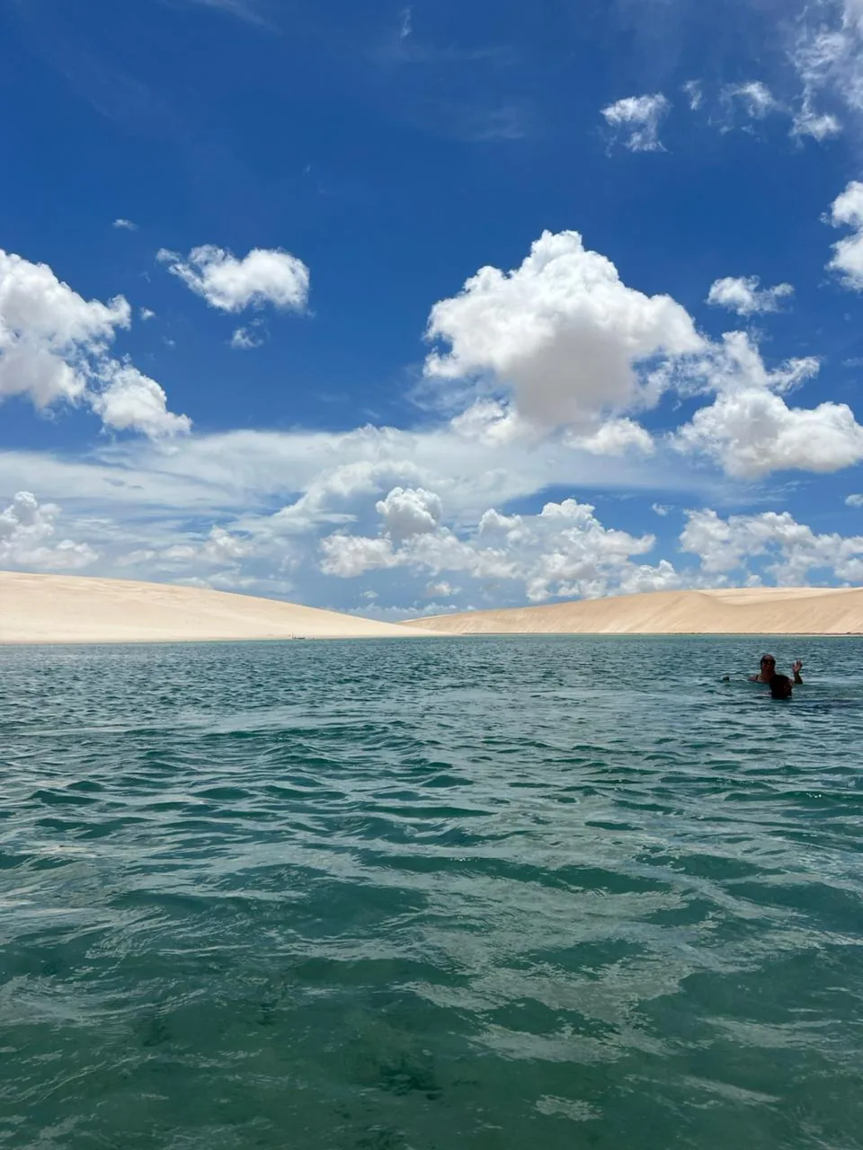 Visitante tomando banho na Lagoa Azul, cercada pelas dunas brancas dos Lençóis Maranhenses