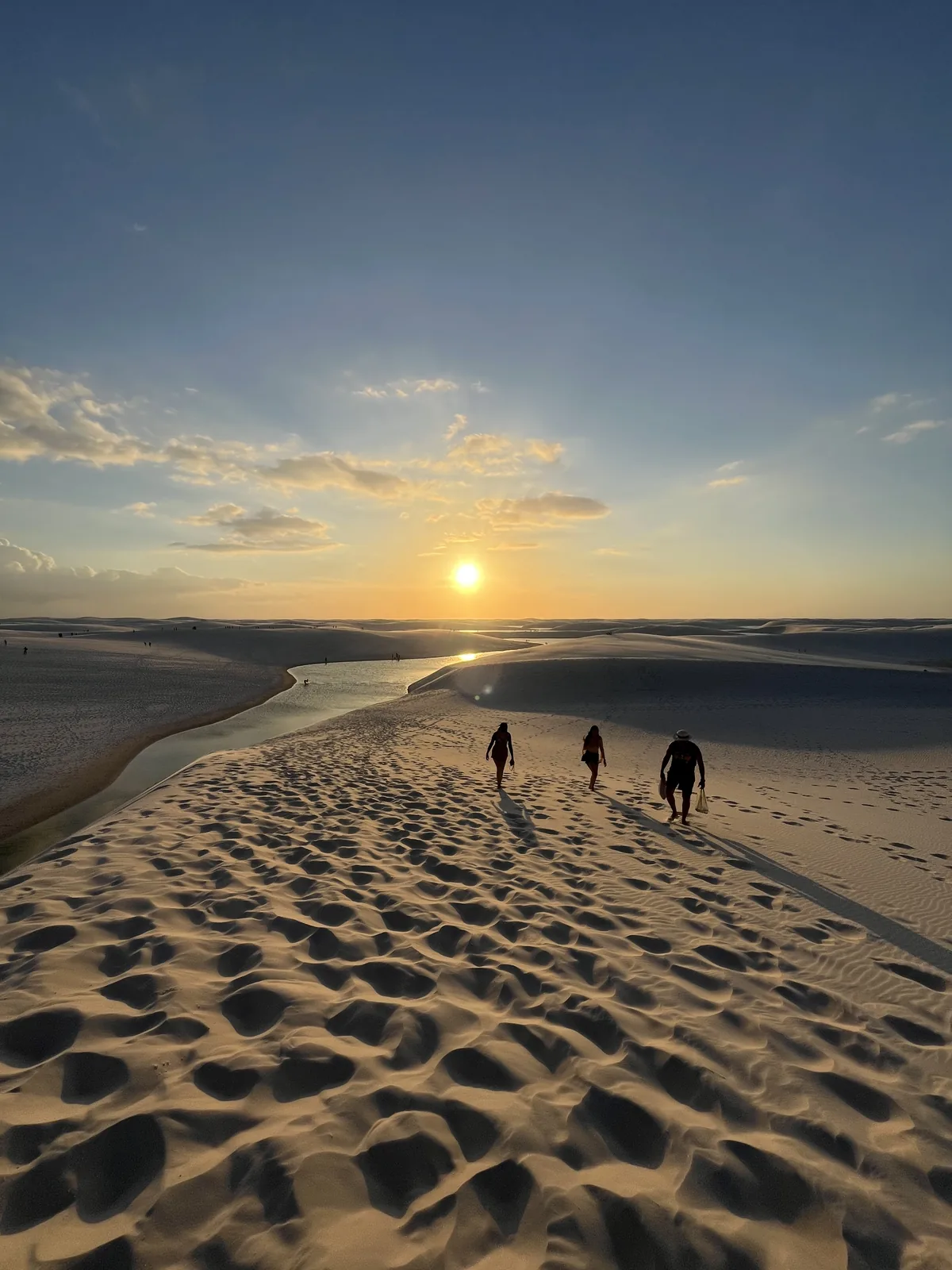 Visitors walking along the dune at sunset in the Lençóis Maranhenses