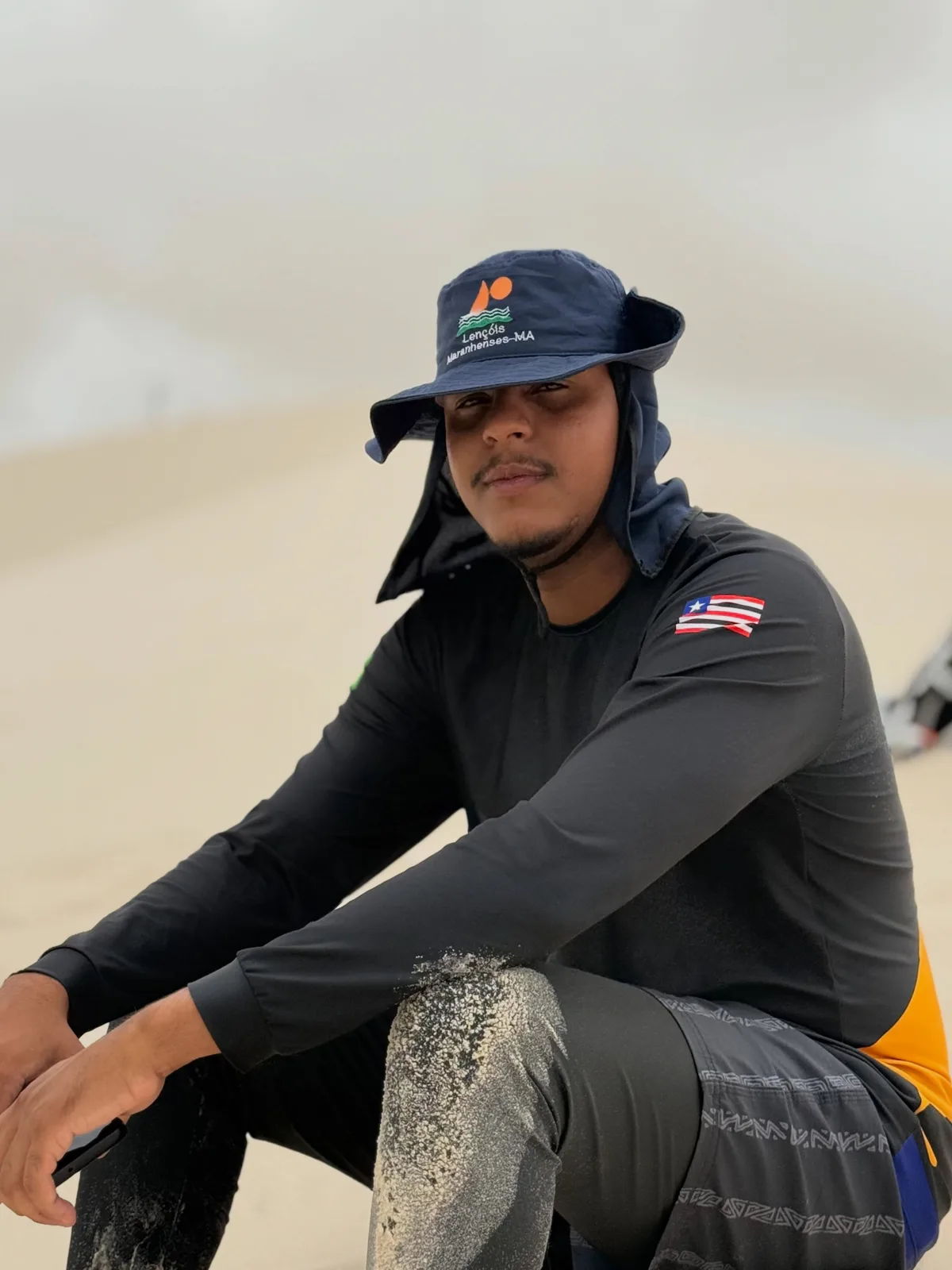 Daniel Nunes, da Amo Lençóis Turismo, sentado na areia das dunas dos Lençóis Maranhenses