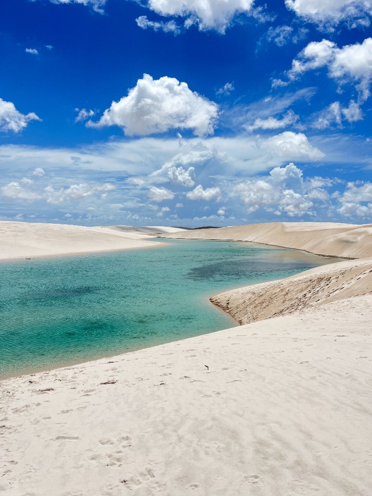 Lagoa azul-turquesa entre dunas brancas