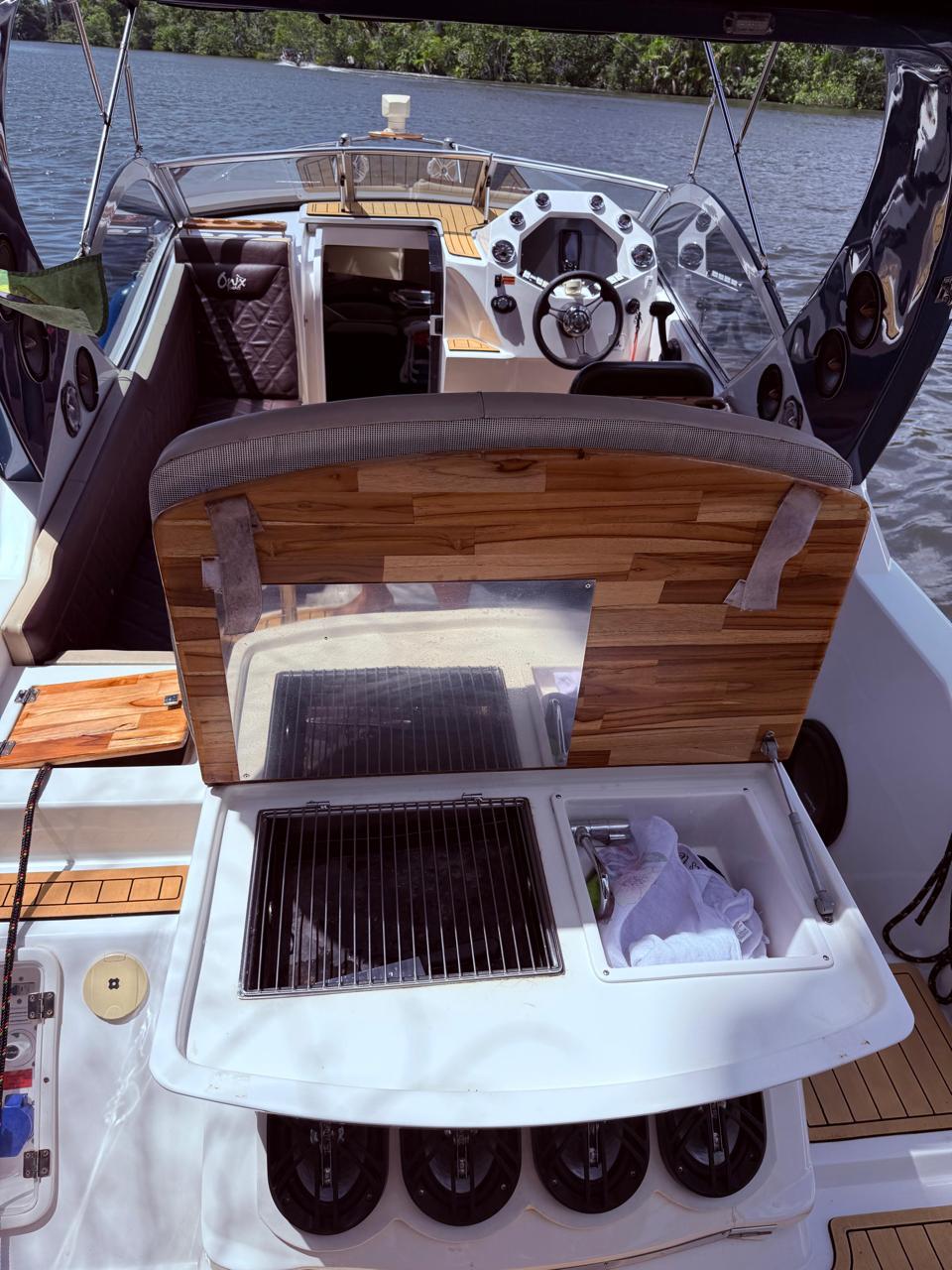 Cockpit da lancha Onix Yachts com timão e churrasqueira aberta na popa