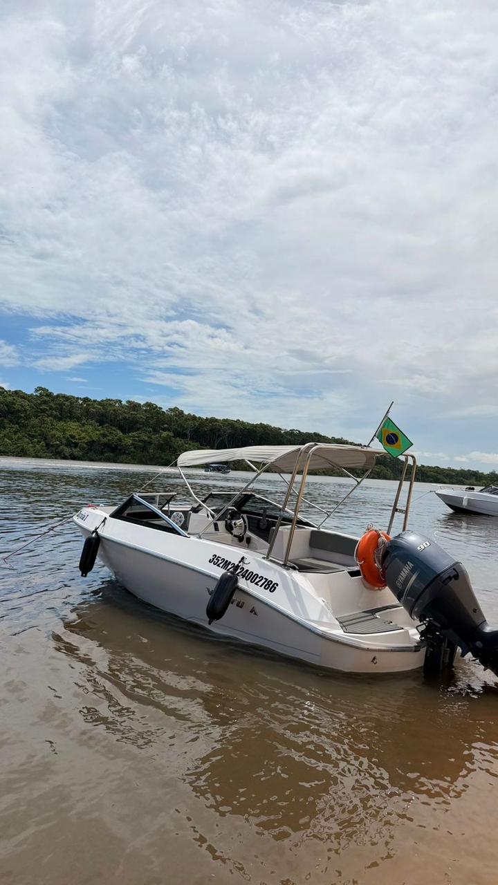 Lancha Zagaia com bandeira do Brasil em águas tranquilas do rio