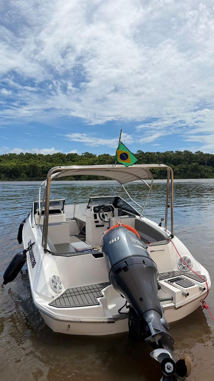 Vista frontal da lancha Zagaia com bandeira hasteada e motor 90 HP